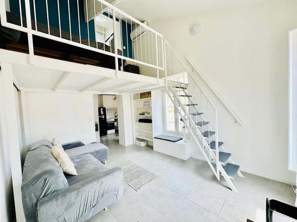 un salon avec un canapé et un escalier dans l'établissement Duplex climatisé - hyper centre - Cœur de Nice, à Nice