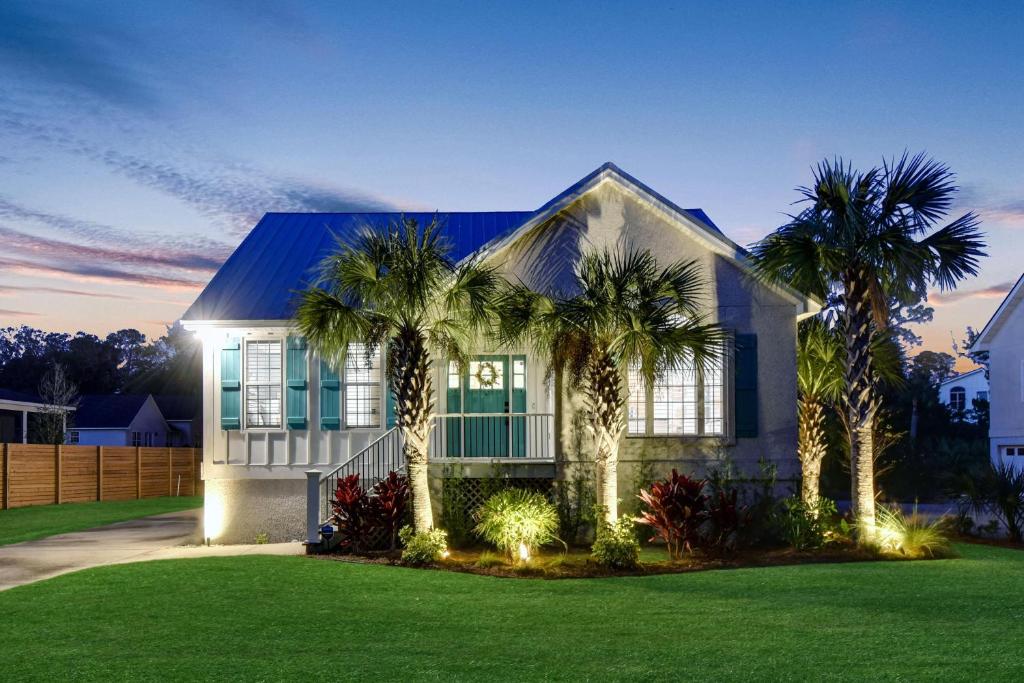 una casa con delle palme davanti di Coral Reef Cottage a Saint Simons Island