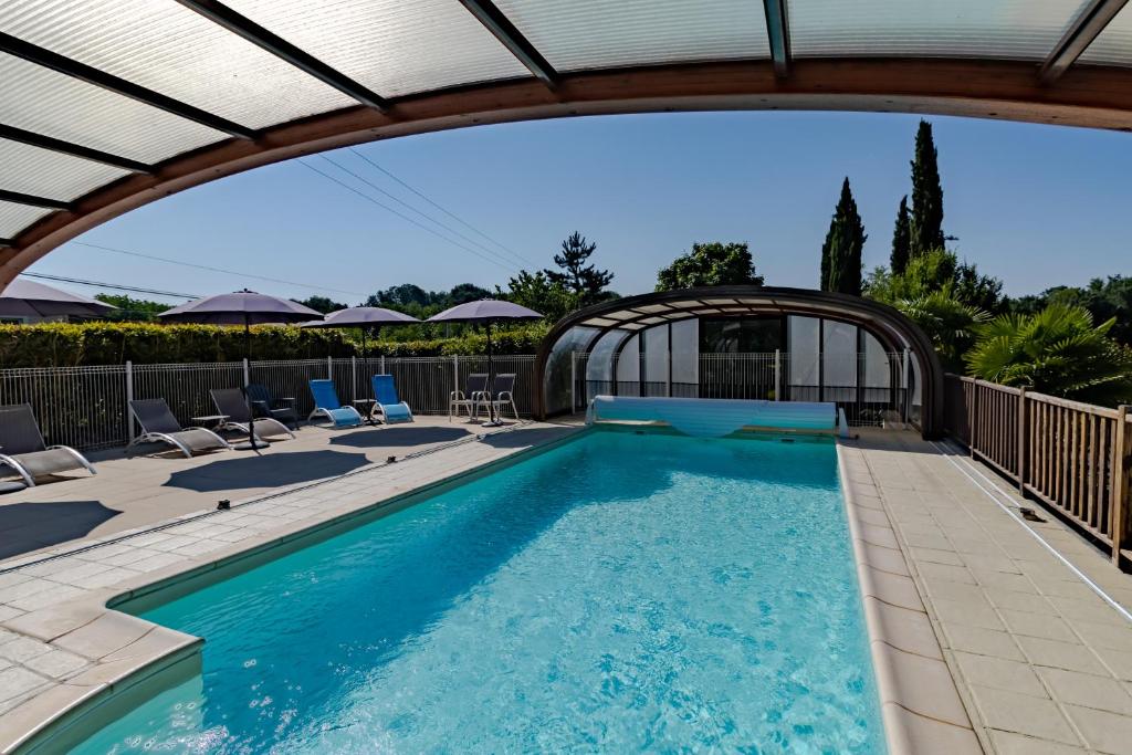- une piscine avec une pergola et des chaises dans l'établissement Maison Fleurie, à Castelnaud-la-Chapelle