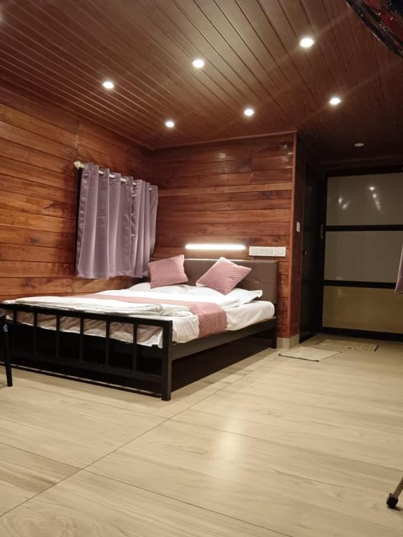 a bedroom with a bed in a room with wooden walls at Rain view wayanad in Wayanad