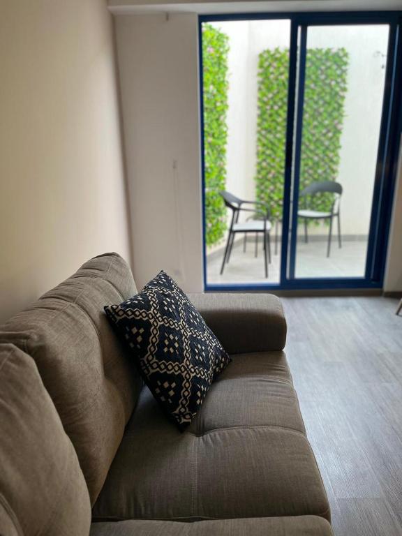 a brown couch with a pillow in a living room at Beautiful cozy apartment in Cusco