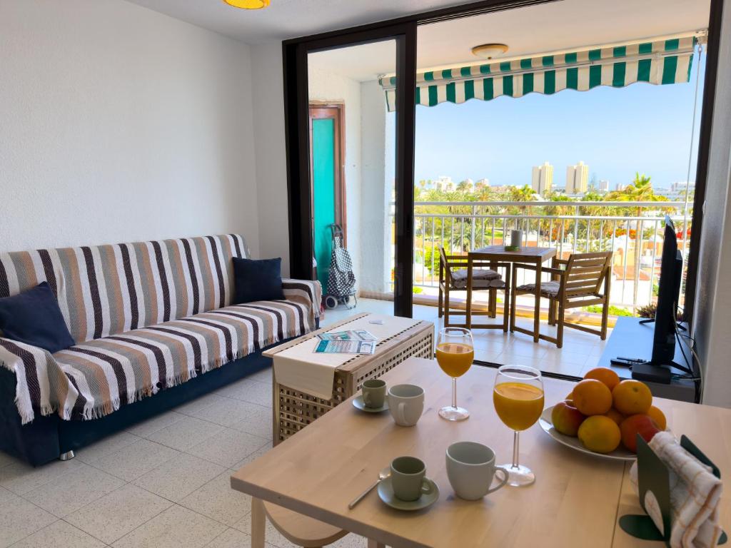 a living room with a couch and a table with wine glasses at Acapulco Beach in Costa de Adeje