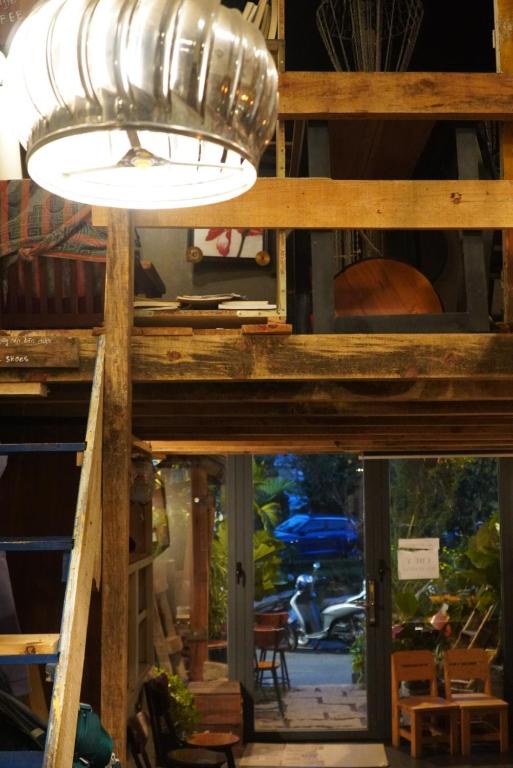 una luce appesa a un tavolo in una stanza di Hostel-John Cafe and Beer a Da Lat