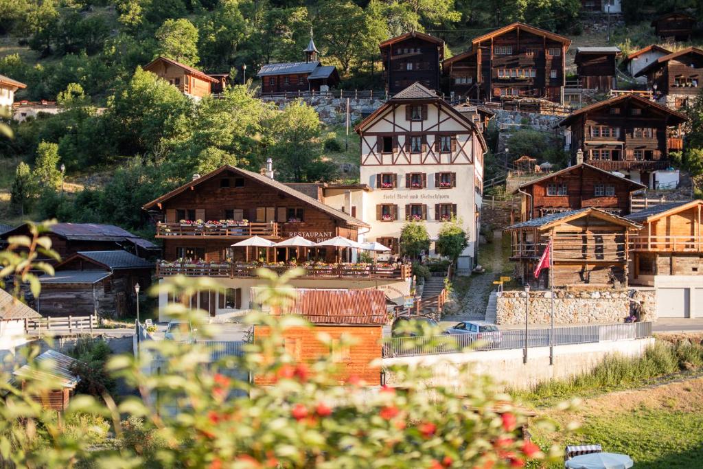 eine Bergstadt mit Holzhäusern auf einem Hügel in der Unterkunft Hotel Nest- und Bietschhorn in Blatten im Lötschental
