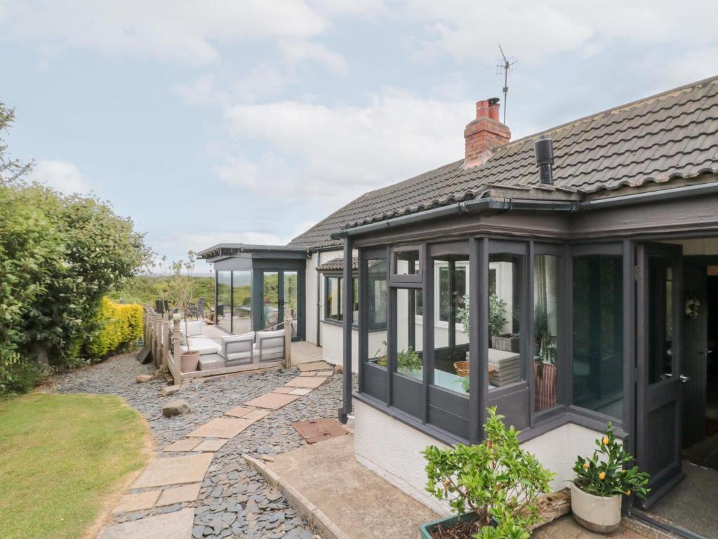 an orchard house with a conservatory and a patio at Sea Haven in Filey