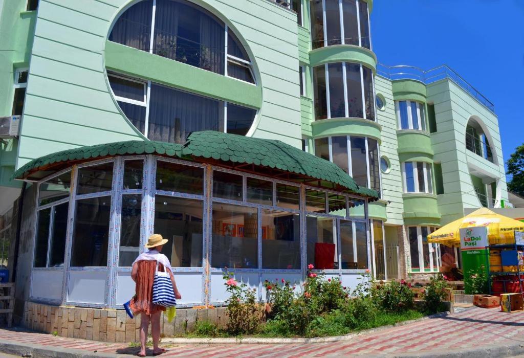 a person standing in front of a building at Pensiunea Meridian in Eforie Nord