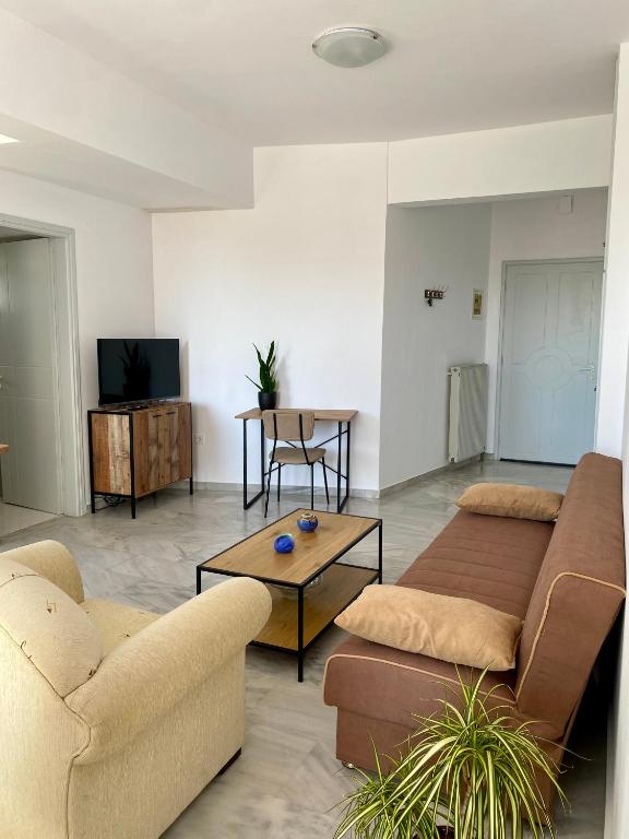 a living room with two couches and a tv at Nearby Sea Studio in Rethymno