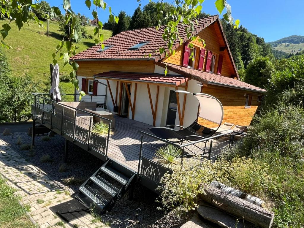 une maison avec deux chaises assises sur une terrasse dans l'établissement La Maison Peter, proche de la nature, 3 étoiles, à Wasserbourg