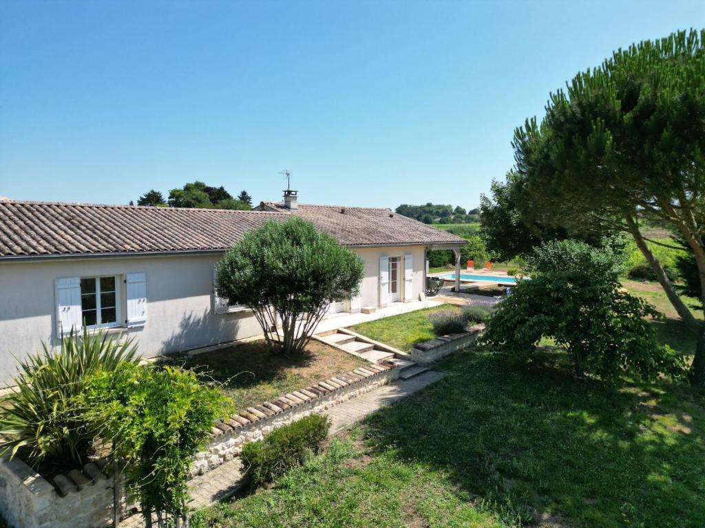 une maison avec un jardin devant dans l'établissement Charmante maison avec piscine au cœur des vignes, à Saint-Philippe-dʼAiguille