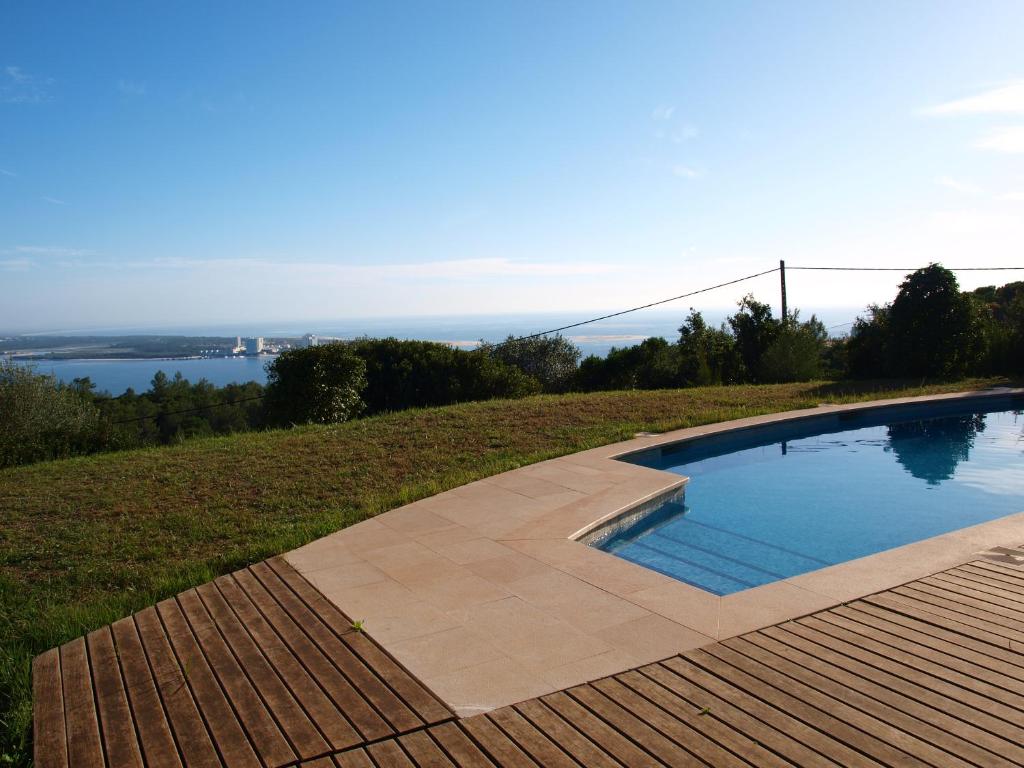 a swimming pool on a hill with a view of the water at Ha Mar ao Luar in Setúbal