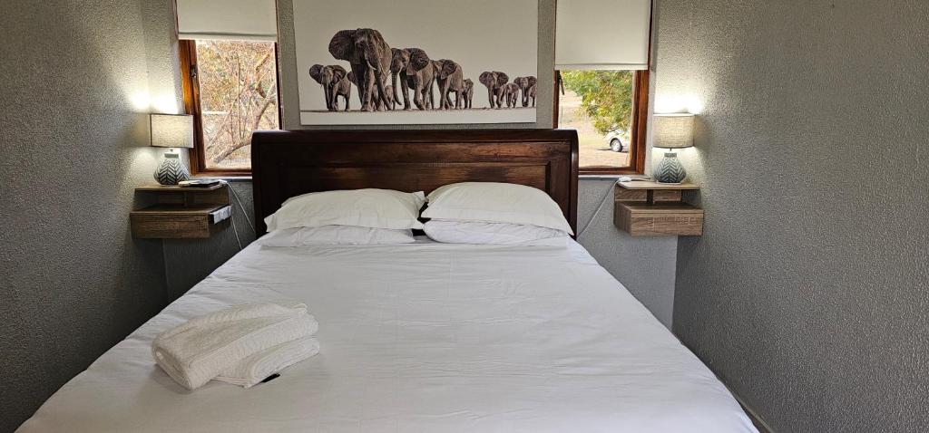 a bedroom with a bed with white sheets and pillows at Acacia at Greenway Woods in White River