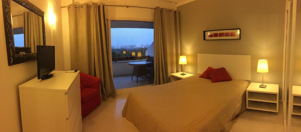 1 dormitorio con 1 cama, TV y ventana en Golf & Mar - T2 Apartment, en Vilamoura