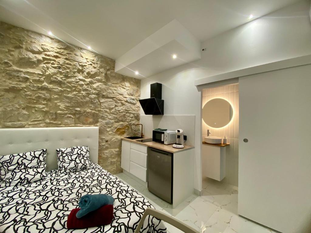 a room with a bed and a kitchen with a counter at Centre - Climatisation - Calme - Cuisine - Wifi - Tramway in Nice