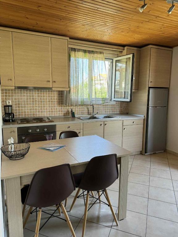 a kitchen with a large wooden table and chairs at Christina Apartment in Ágios Konstantínos