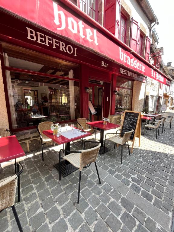 a restaurant with tables and chairs in front of a building at Hôtel Restaurant Le Beffroi in Salers