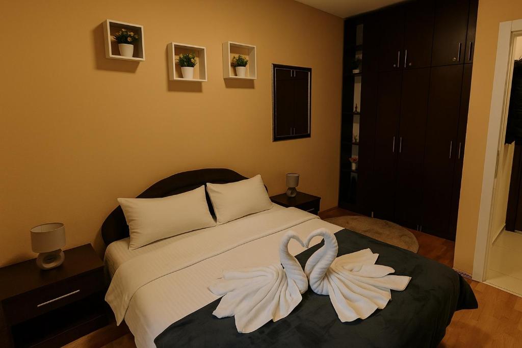 a bedroom with a bed with two swans on it at Apartman Bella vita 2 in Zlatibor