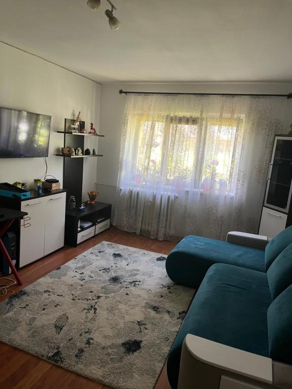 a living room with a blue couch in front of a window at Apartament Craiova in Craiova