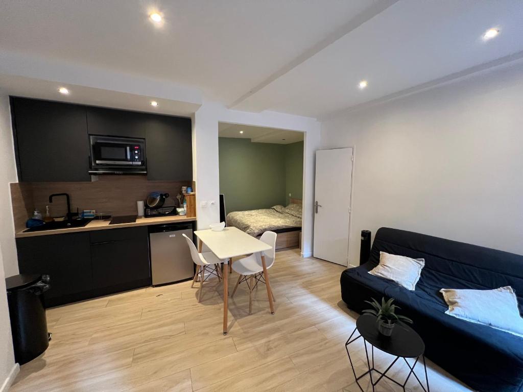 un salon avec un canapé bleu et une cuisine dans l'établissement Superbe studio avec coin nuit vieux nice !, à Nice