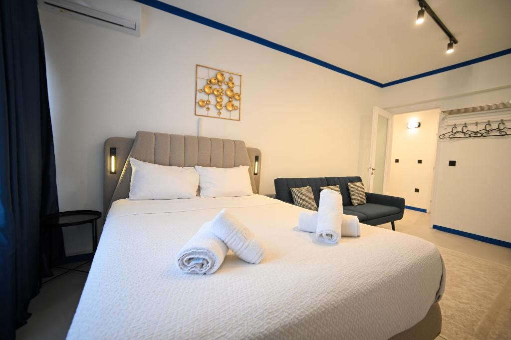 a bedroom with a large white bed with towels on it at Syntagma Center Suite by Zeus Suites in Athens