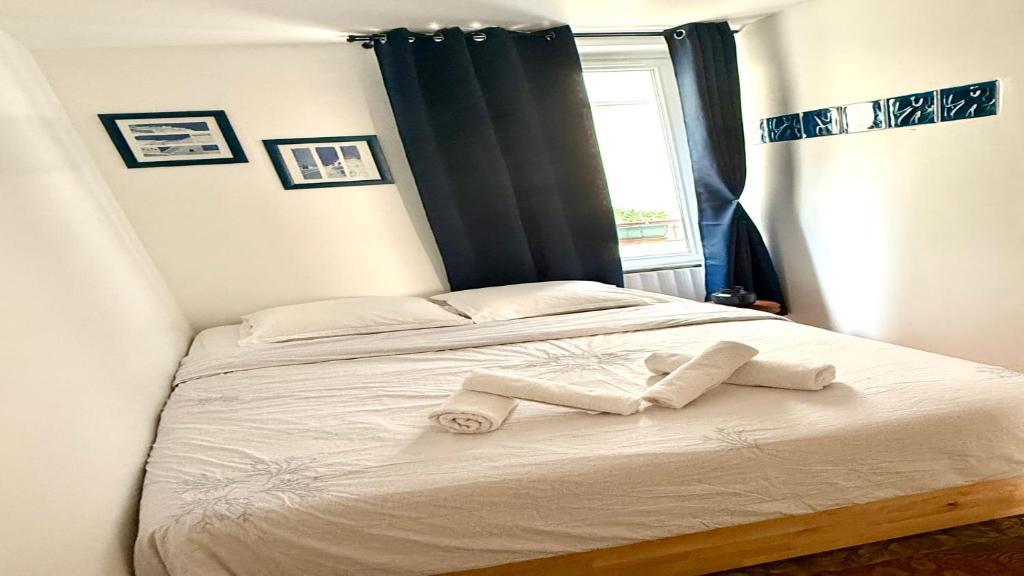 une chambre avec un lit avec deux serviettes dessus dans l'établissement Charming Apartment near The Eiffel Tower, à Paris