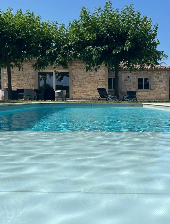 une piscine avec de l'eau bleue devant un immeuble dans l'établissement Villa Evanine, à Saint-Privat-de-Champclos