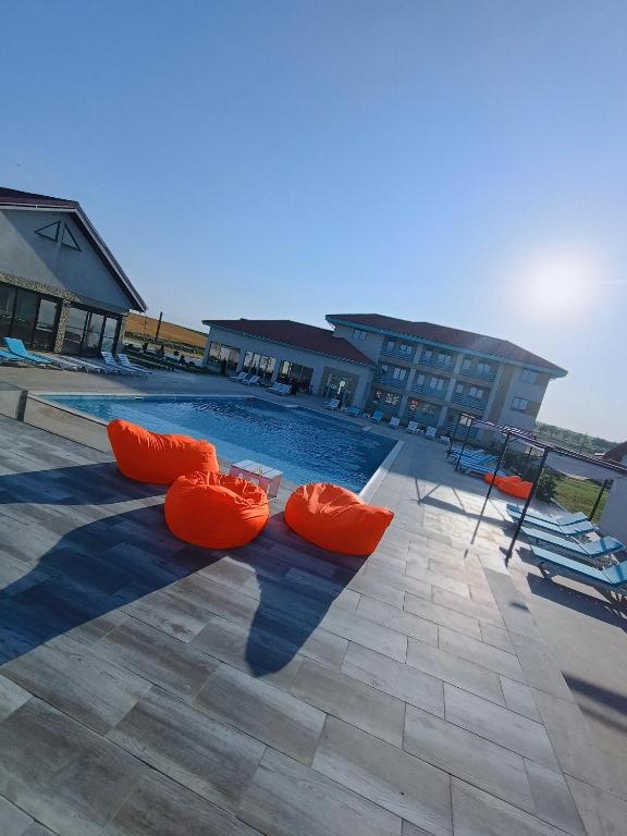 a swimming pool with orange inflatables on the ground at Pensiunea Aura Deltei in Murighiol