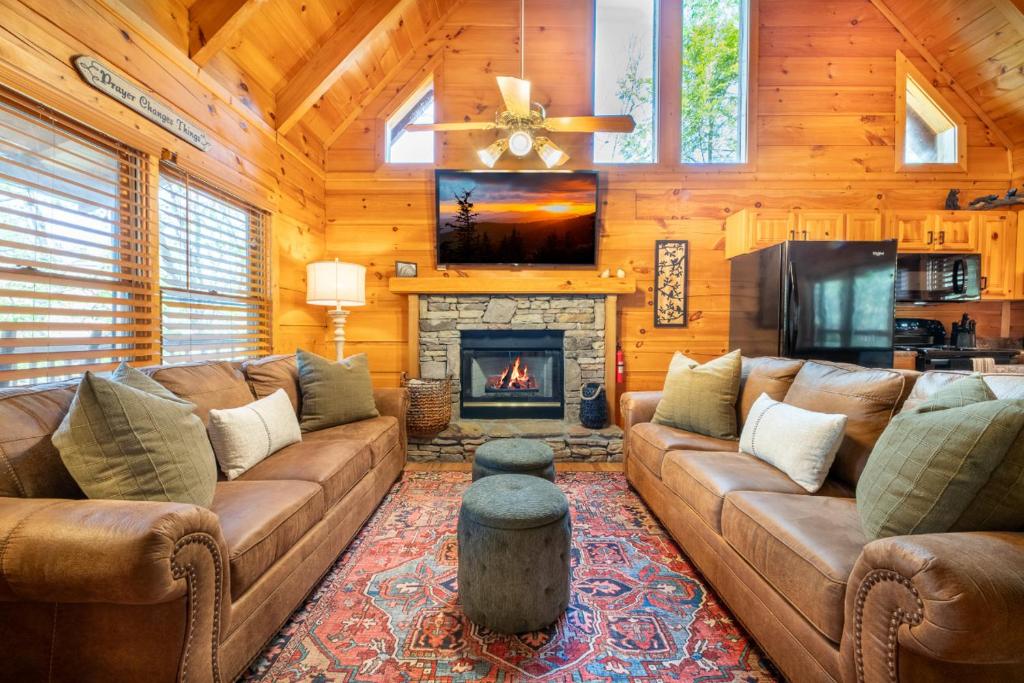 een woonkamer met een bank en een open haard bij Roudy’s Roost By Avada Properties in Pigeon Forge