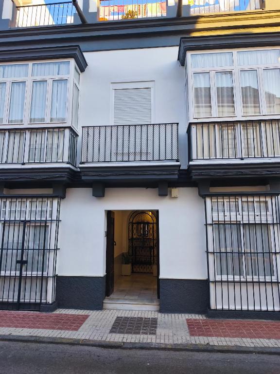 a white building with a door and a balcony at Casa San Juan 55 - Centro Sanlúcar in Sanlúcar de Barrameda