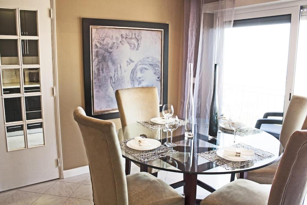 a dining room with a glass table and chairs at Sunset Beach Apartment in Vila Praia de Âncora