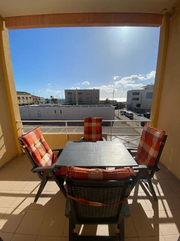 a table and chairs on a balcony with a view at Studio front de mer Valras-Plage 2-4 personnes in Valras-Plage