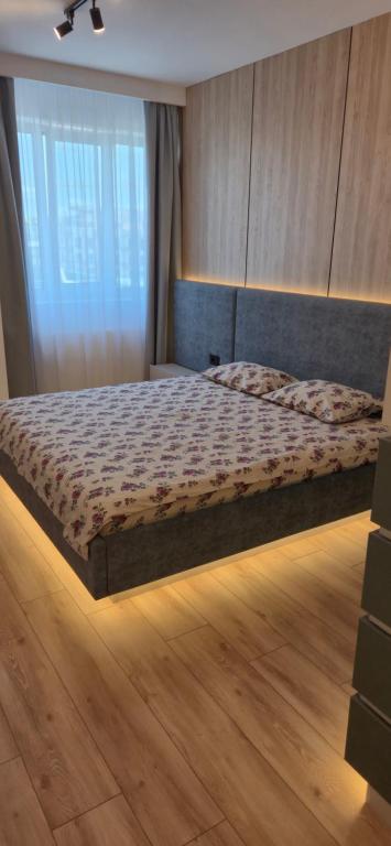 a bedroom with a bed with a wooden floor at concept 9 in Târgu-Mureş