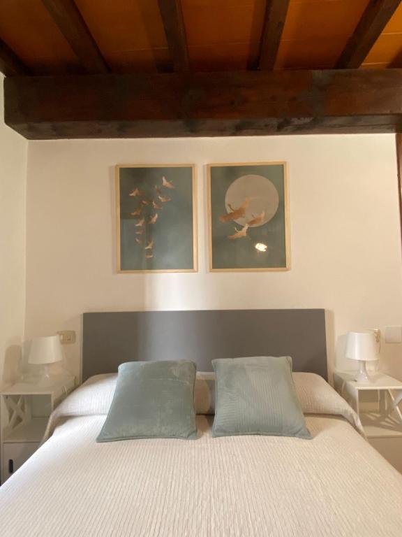 a bedroom with a bed with two pictures on the wall at La Chiocciola in Parma