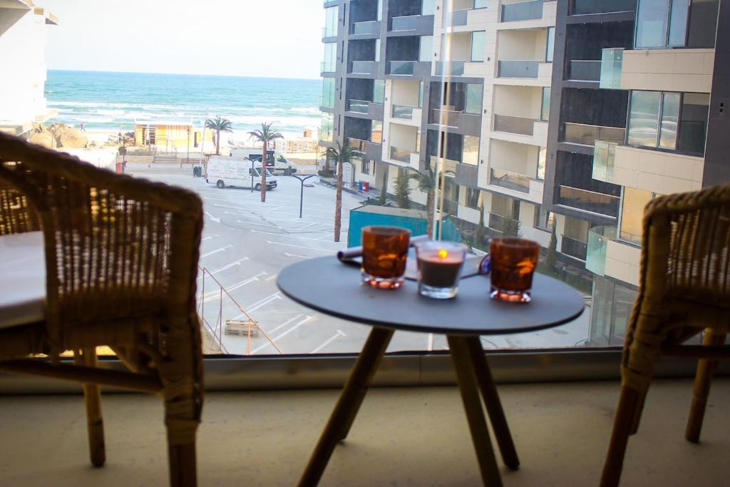 un tavolo con due candele sopra davanti a una finestra di Sea Shine Apartament, frontal sea view a Mamaia Nord - Năvodari
