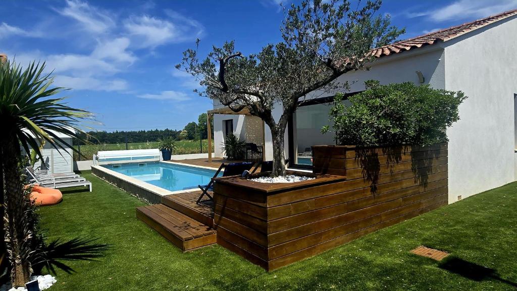 une cour arrière avec une piscine et un arbre à côté d'une maison dans l'établissement Villa 8 personnes en Provence - 3 nuits min, à Grans