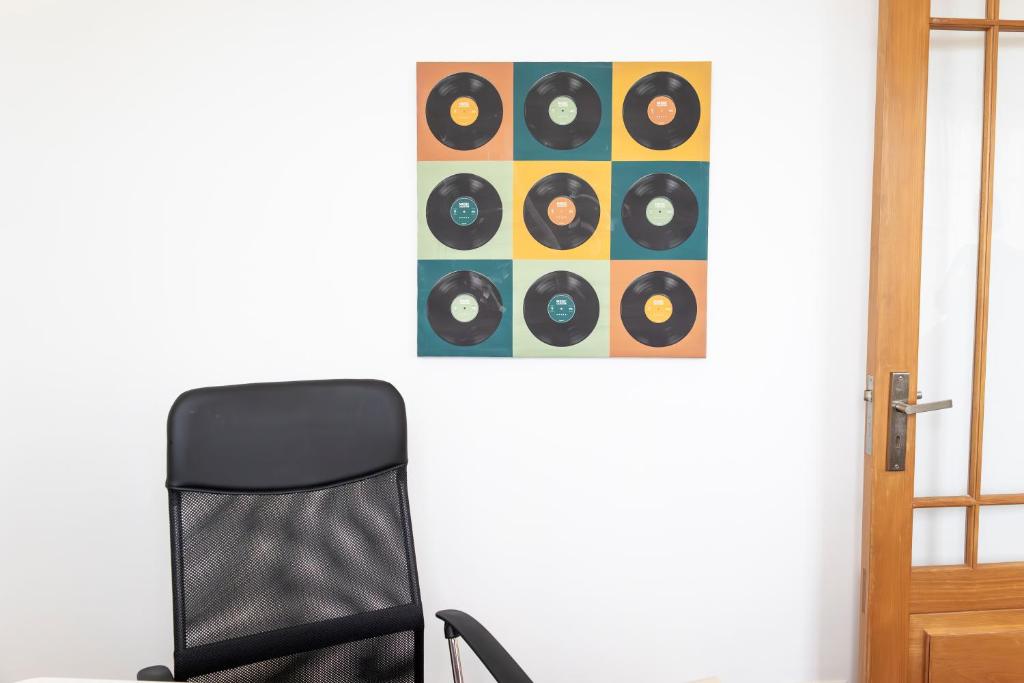a black chair next to a framed picture of records at Casa Borda da Rocha in Nordeste