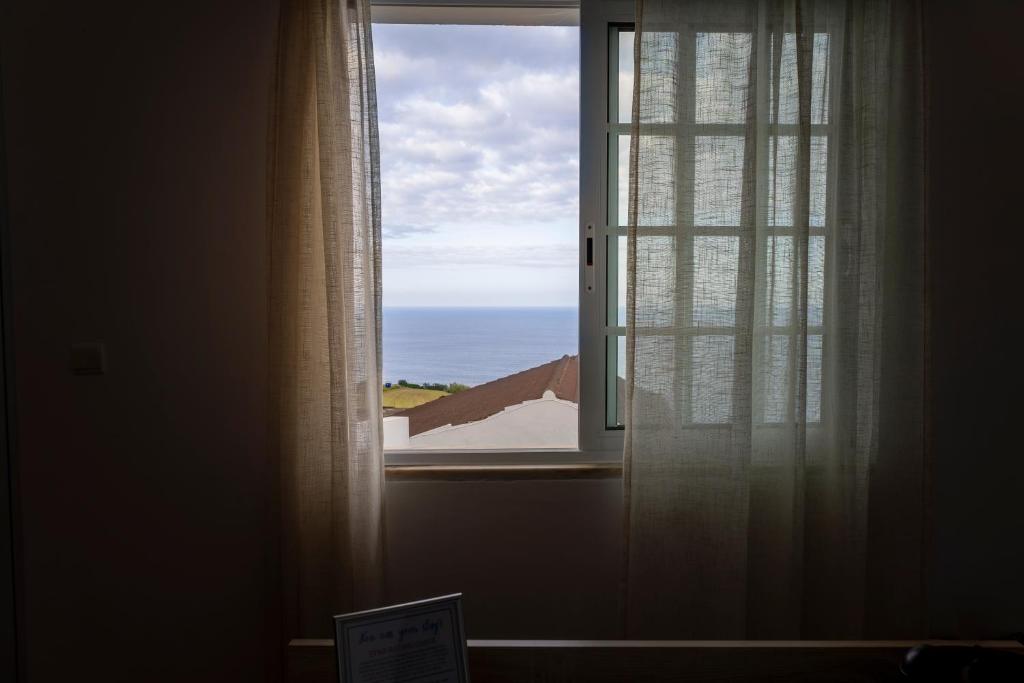 a window with a view of the ocean at Casa Borda da Rocha in Nordeste