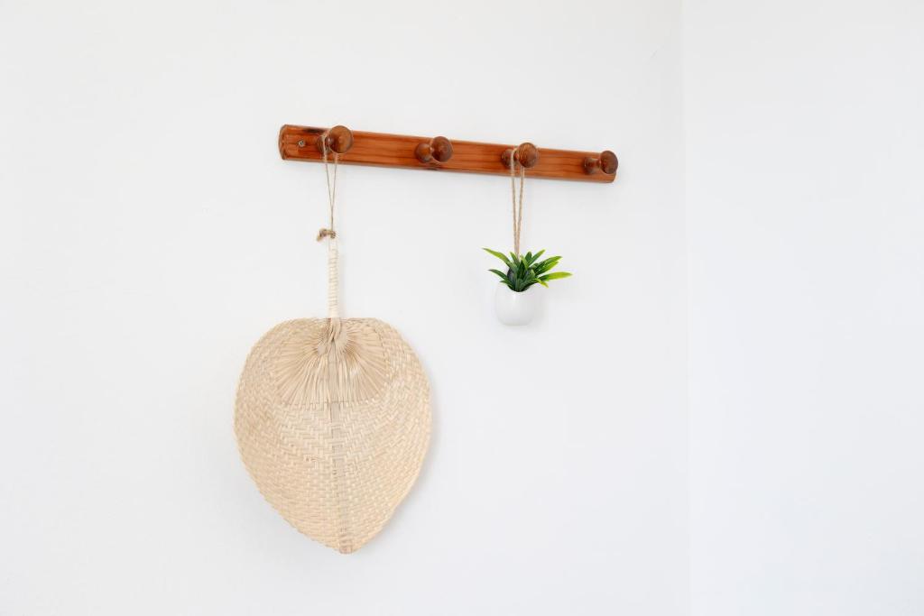a hammock hanging from a wooden pole with a plant at Casa Borda da Rocha in Nordeste