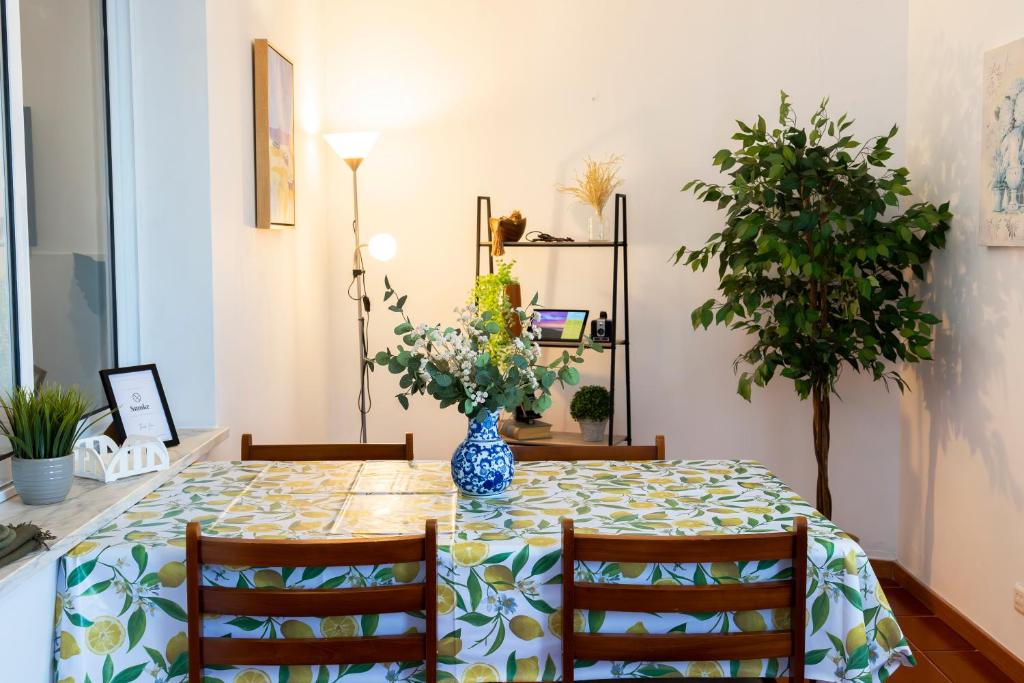 a dining room table with a vase of flowers on it at Casa Borda da Rocha in Nordeste