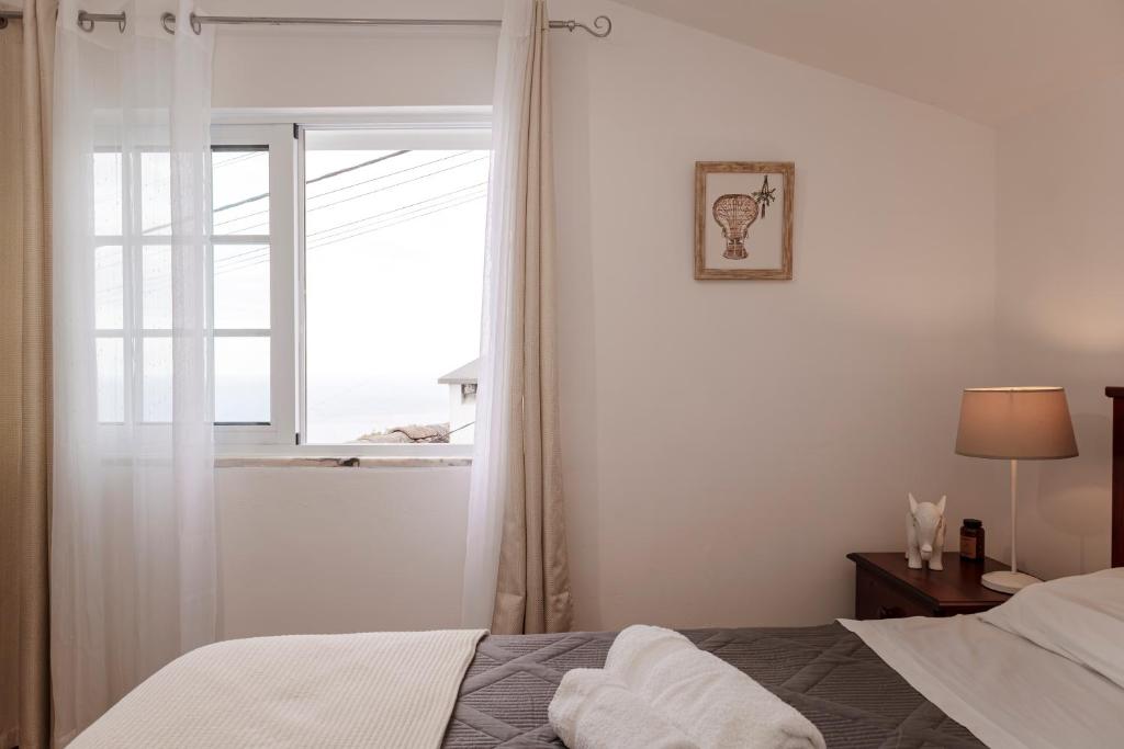 a bedroom with a bed and a window at Casa Borda da Rocha in Nordeste