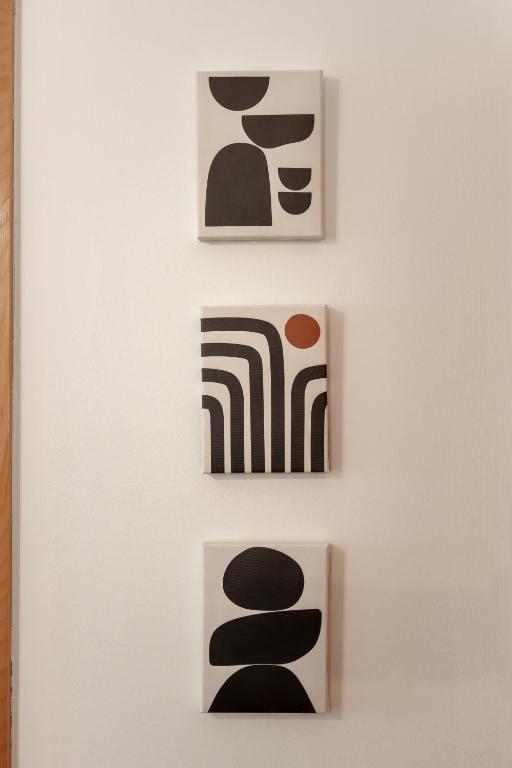 three pieces of art hanging on a wall at Casa Borda da Rocha in Nordeste