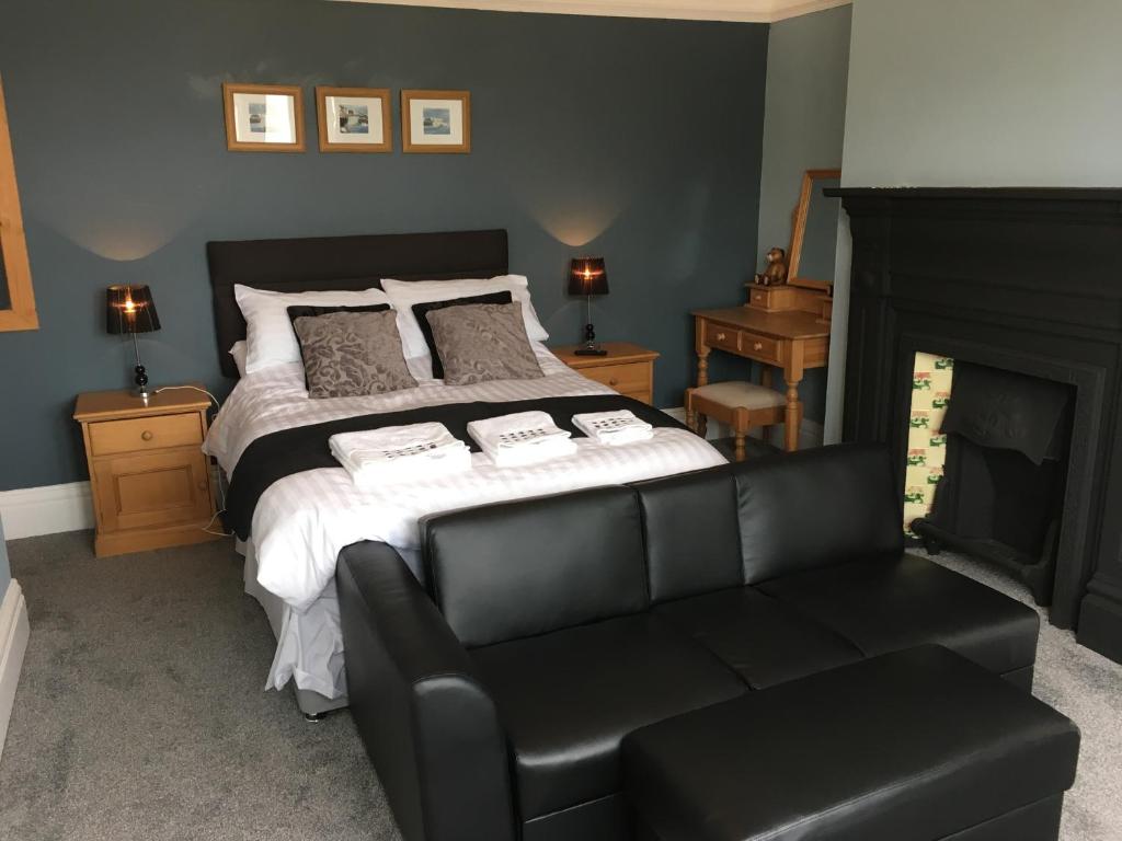 um quarto com uma cama e um sofá de couro preto em Spaview em Bridlington