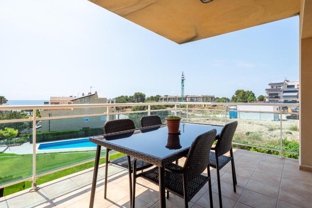 Un patio con una mesa y sillas en un balcón. en Hauzify I Apartament Cala Pepo 2, en L'Ametlla de Mar