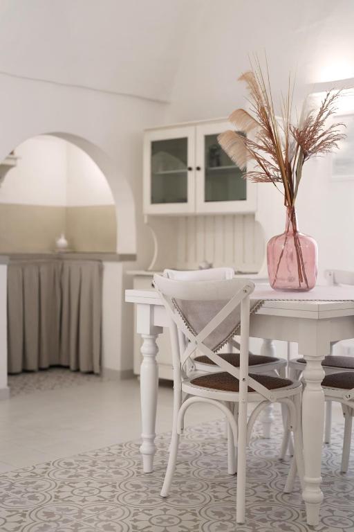 a white dining room with a white table and chair at Le Cementine - Apulian Rooms in Fasano