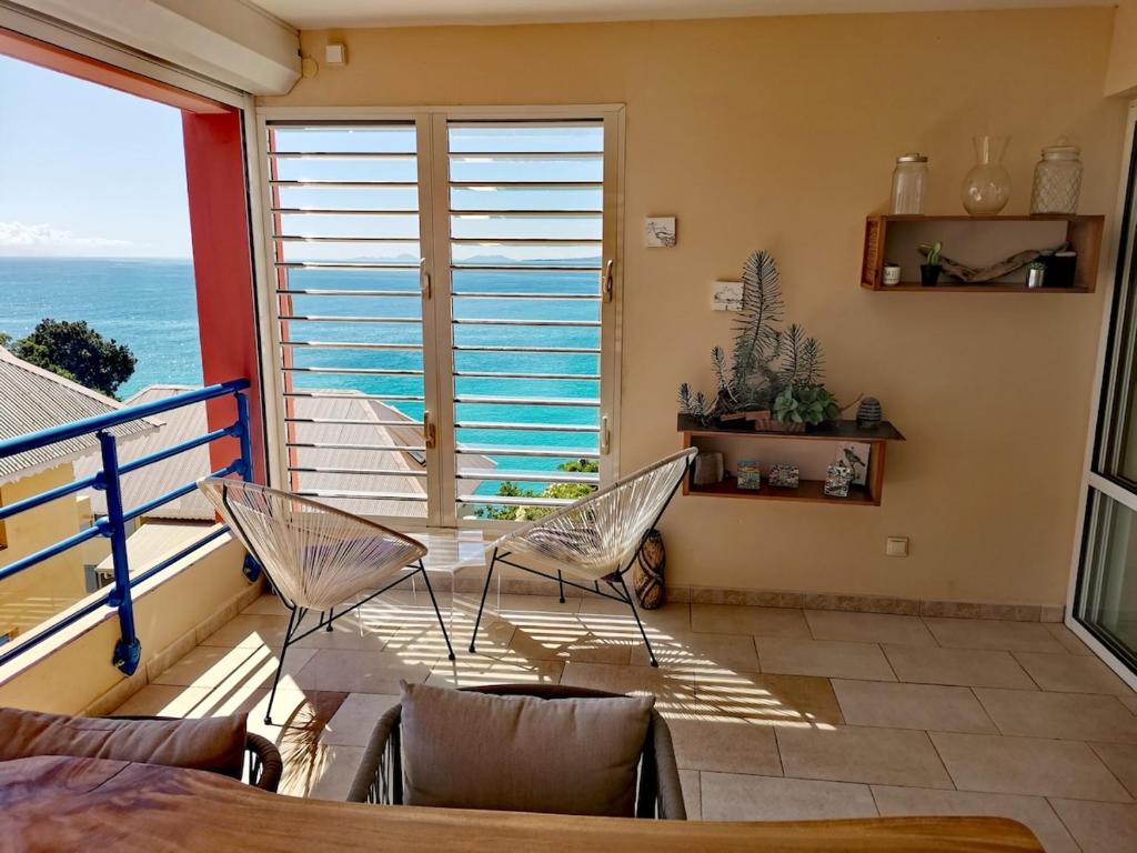 a balcony with chairs and a view of the ocean at Horizon Mer in Le Gosier
