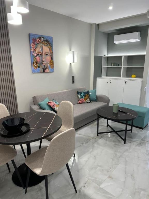una sala de estar con un sofá, una mesa y sillas en A living skg 2 Quiet Luxury, en Tesalónica