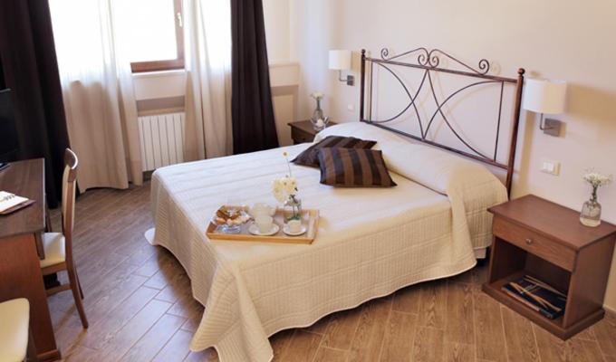 una camera da letto con un letto con un vassoio di cibo sopra di Fontana Murata Resort & spa a Borgo Regalmici