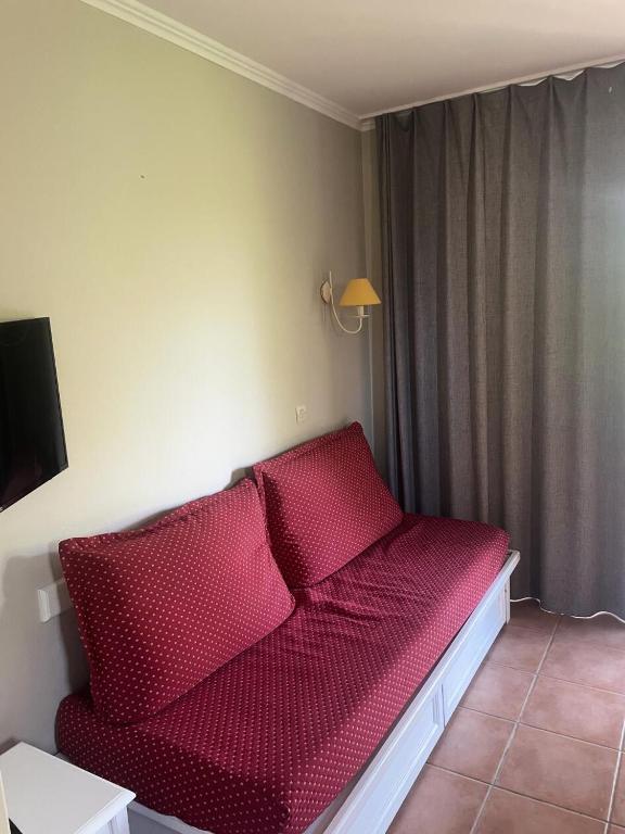 un lit rouge dans un coin de pièce dans l'établissement Village Pont Royal en Provence - maeva Home - Appartement 2 Pièces 5 Personnes Sélection MAE-2164, à Mallemort
