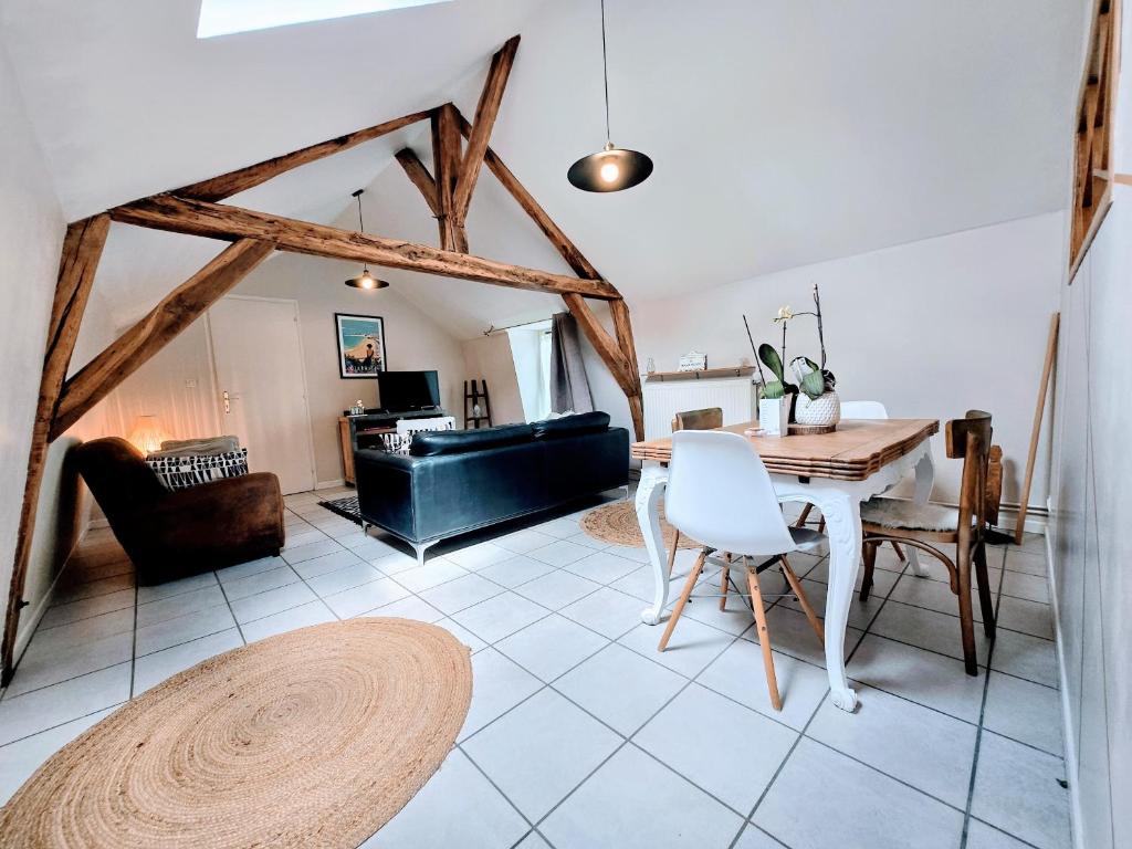 a living room with a table and a couch at Appartement Cozy - Dernier Étage - Parking Auxerre in Auxerre