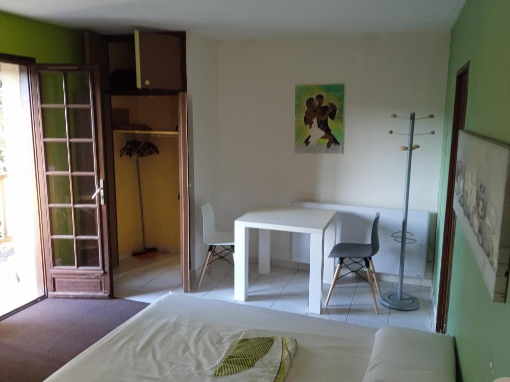 a bedroom with a white table and a table and chairs at Cours ruralité tranquillité in Cours