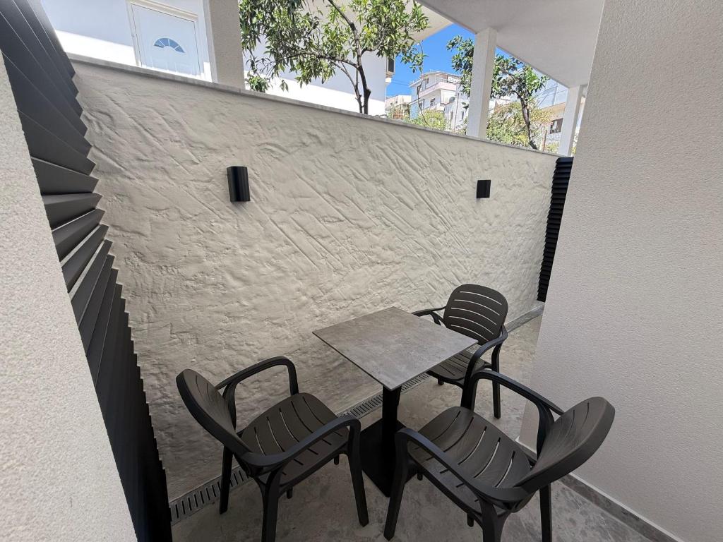 a table and chairs on a balcony with a brick wall at Hotel Barjami in Sarandë